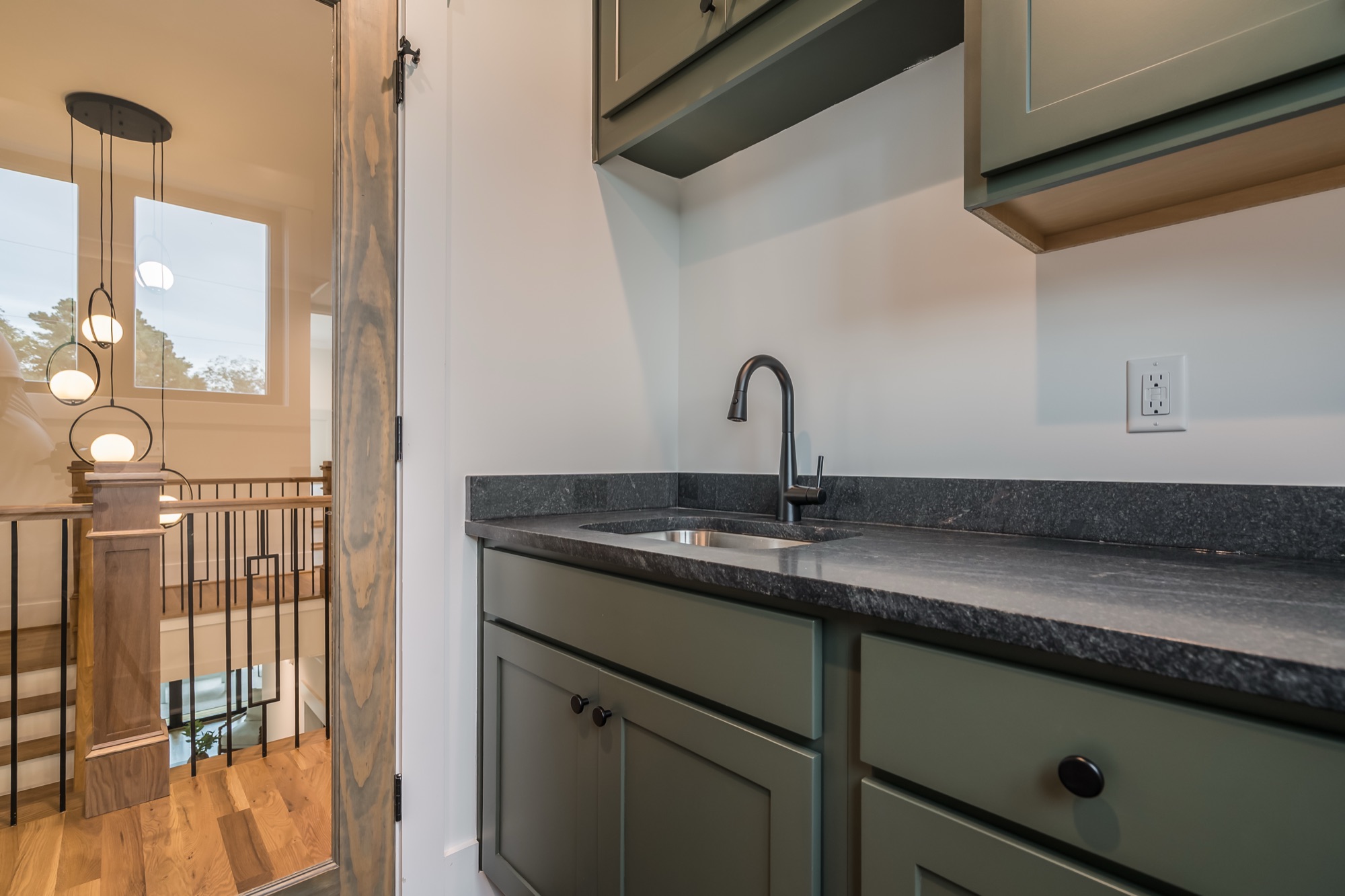 Sage cabinetry with brass hardware in a Gemstone home