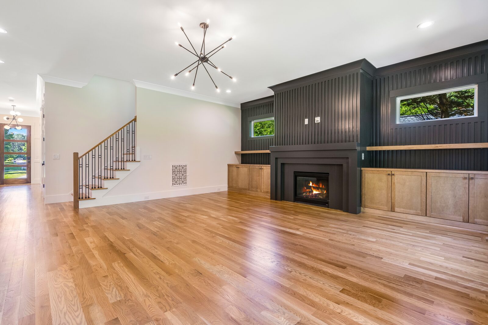 Great room with a lit fireplace in a Gemstone custom home
