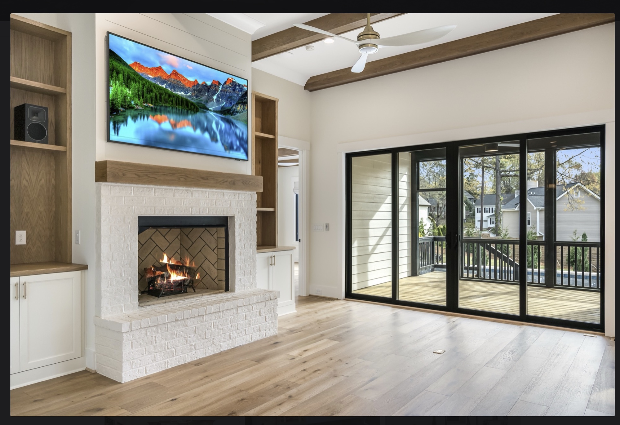 Family room with integrated TV, brick fireplace, and screened porch view