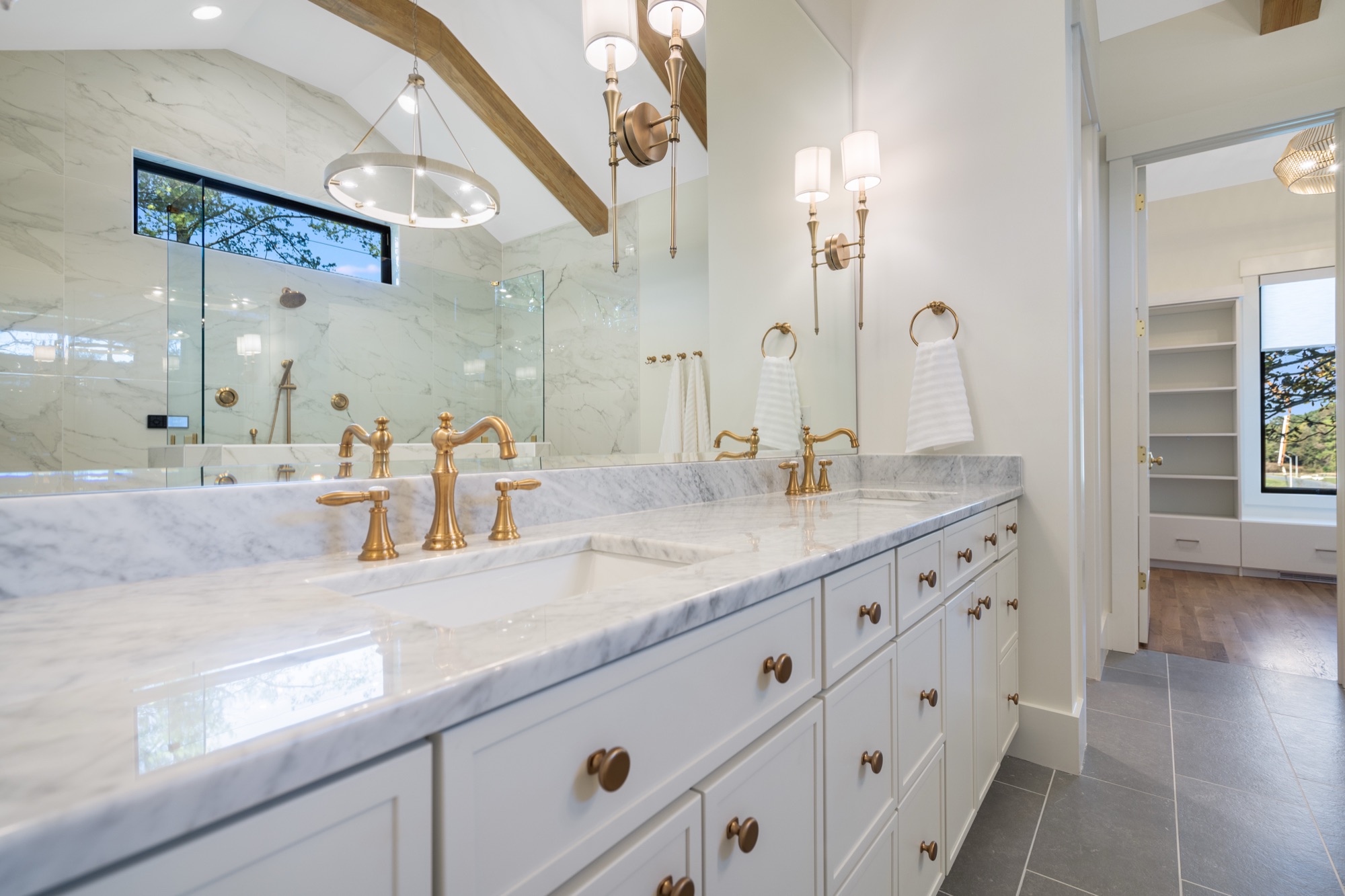 Brushed gold faucets on marble vanity