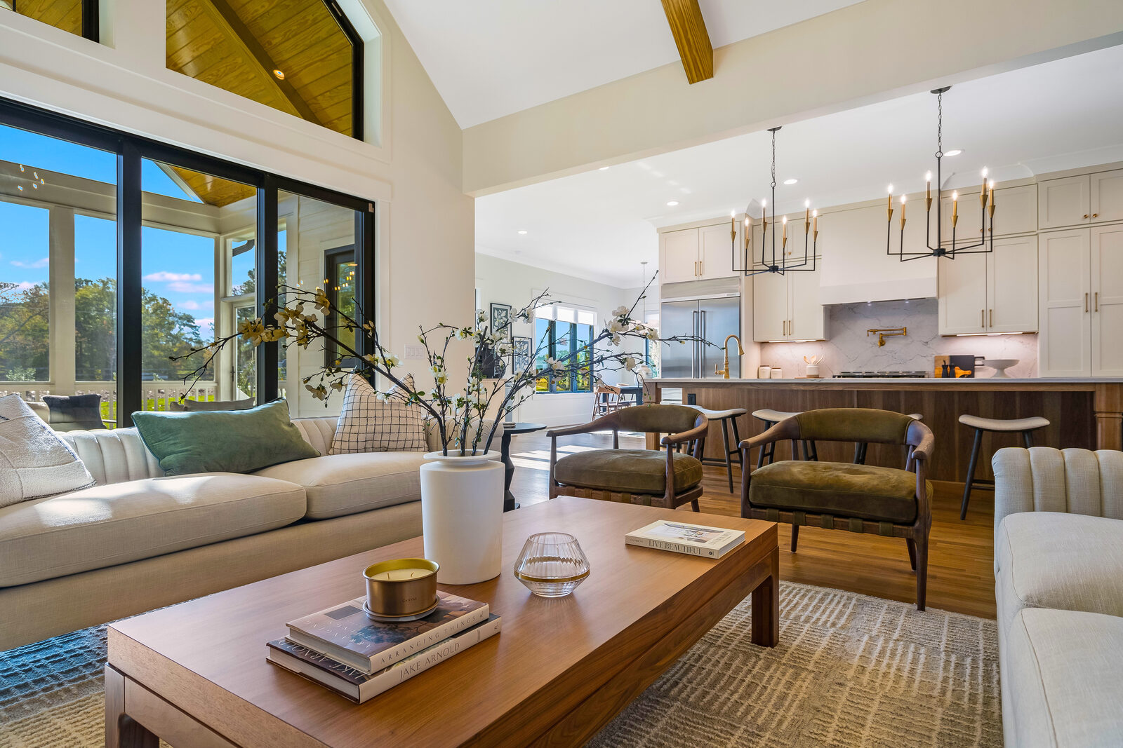 Vaulted, beamed great room opening to the kitchen in a Gemstone custom home