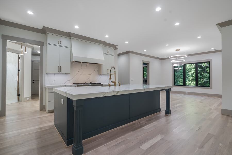 Open kitchen with a marble waterfall island in a Gemstone custom home