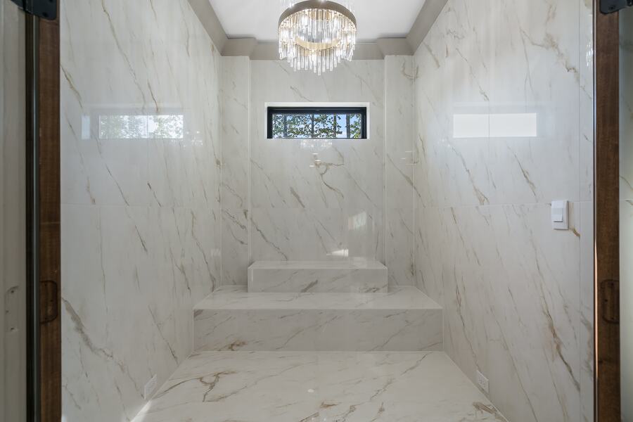 Full-height marble shower with a chandelier in a Gemstone custom home