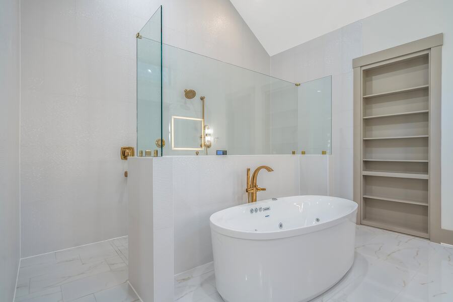 Primary bath with a freestanding tub and brass floor filler in a Gemstone custom home